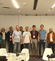 Photograph of 14 meeting attendees representing a variety of service providers in a conference room